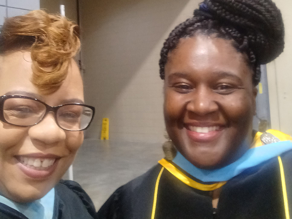 Tiyacca Simms Jones and a friend wearing graduation regalia