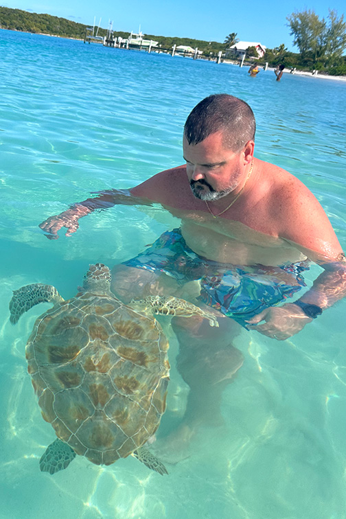 Russ Carmichael swimming with a sea turtle