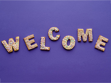 Letters spelling out the word 'welcome' on a purple backdrop