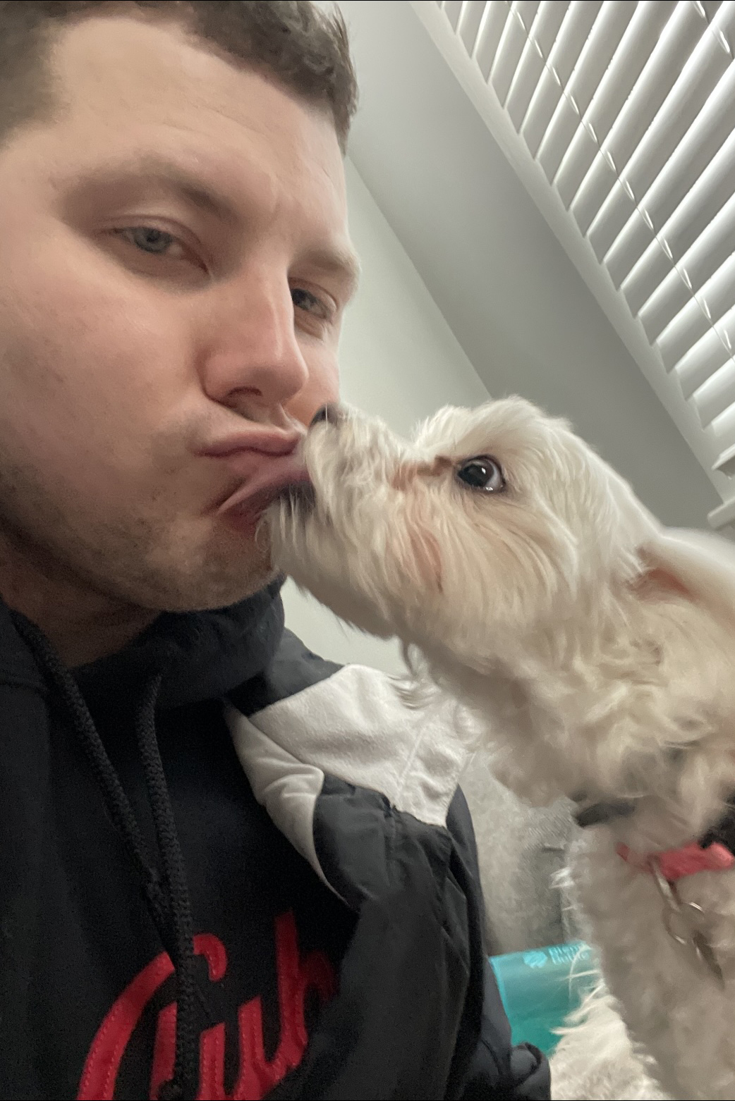 Joe Ellis kissing a white dog