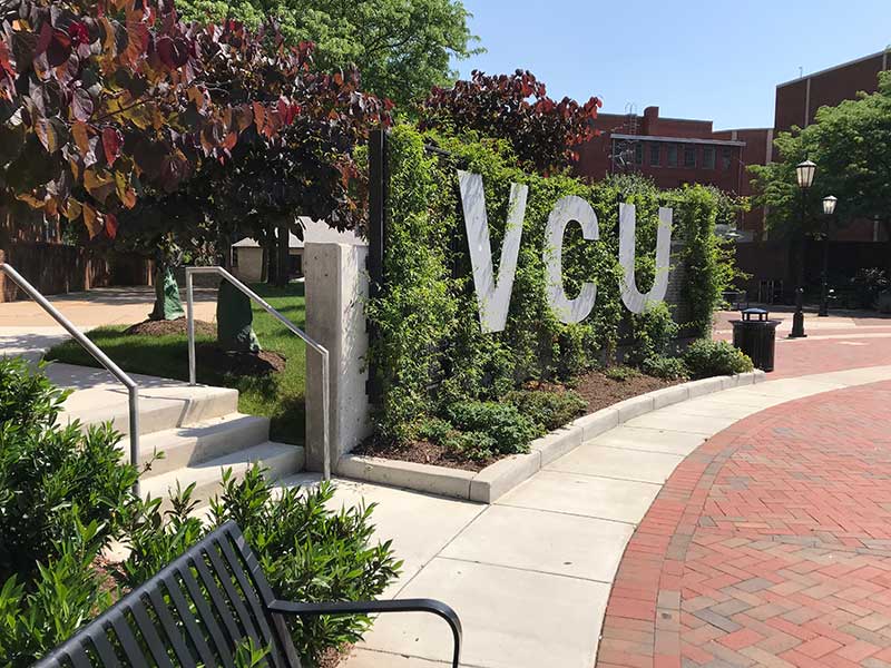 the letters v.c.u. inset in greenery on campus