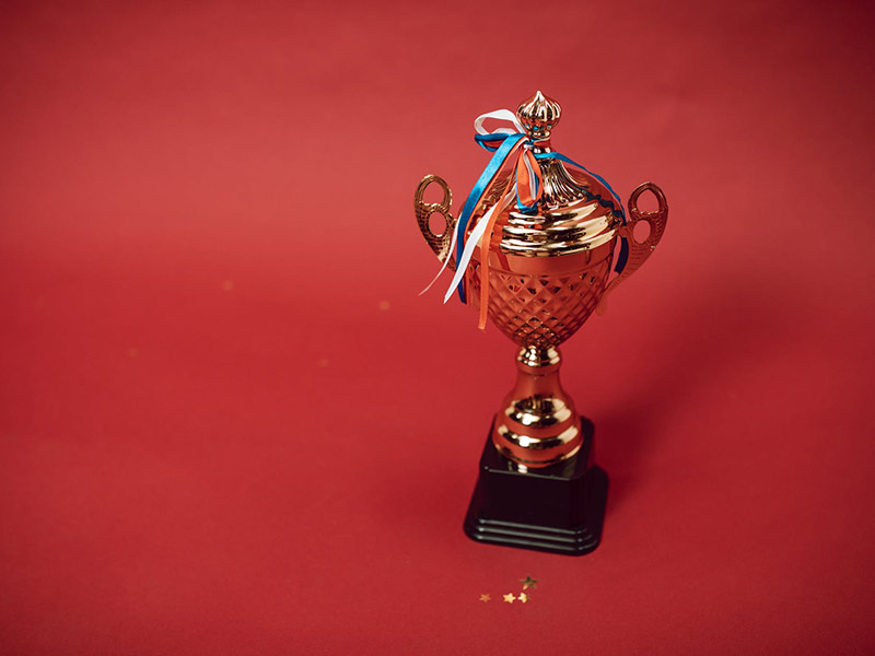 a golden trophy with a ribbon tied to the top